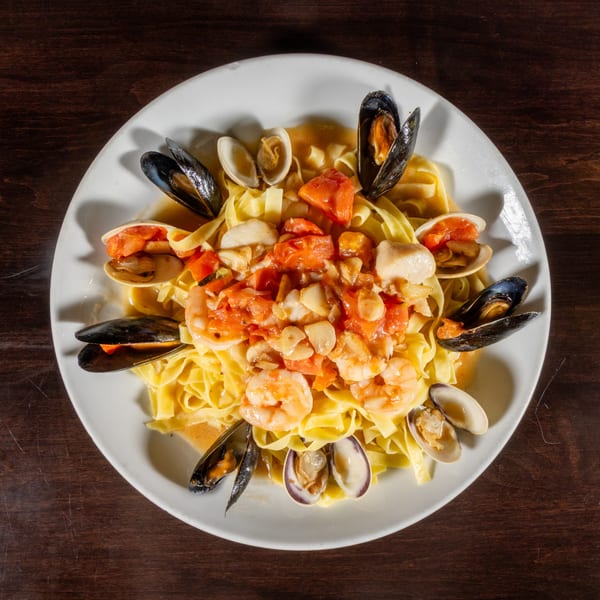 Seafood pasta dish with mussels, clams, shrimp, and scallops in a tomato sauce over fettuccine.